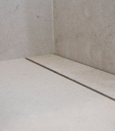 Sistema de desagüe oculto bajo pieza cerámica, diseñado para duchas con pendientes a 1, 2 o 4 direcciones.
