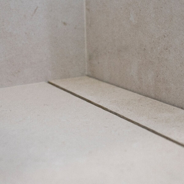 Sistema de desagüe oculto bajo pieza cerámica, diseñado para duchas con pendientes a 1, 2 o 4 direcciones.