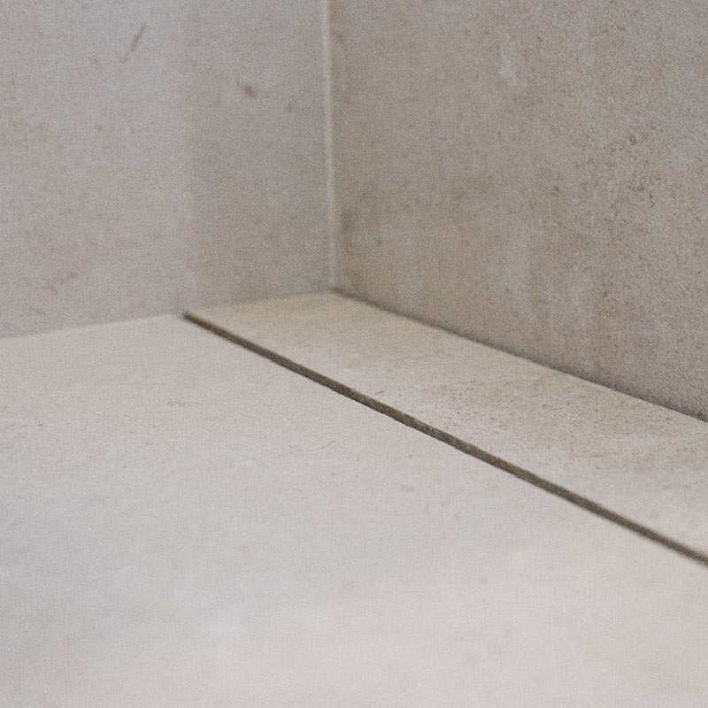Sistema de desagüe oculto bajo pieza cerámica, diseñado para duchas con pendientes a 1, 2 o 4 direcciones.